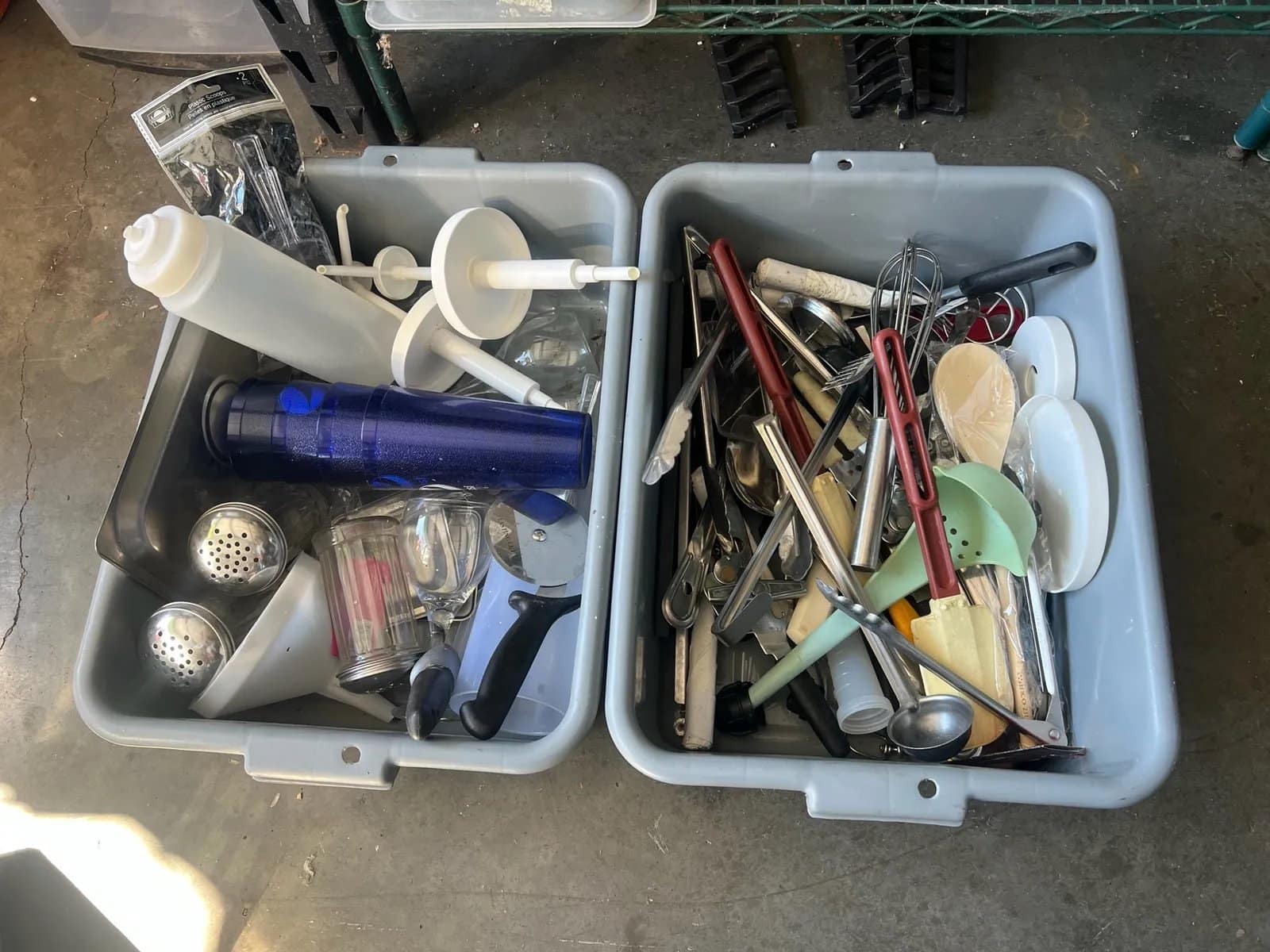 assorted-kitchen-utensils-and-tools-in-two-grey-busing-totes-2e57e9