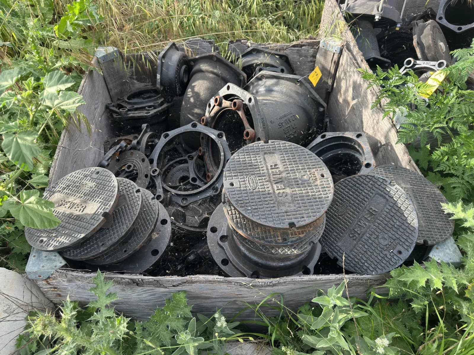 crate-of-assorted-industrial-iron-pipe-fittings-and-manhole-covers-mnp71g54