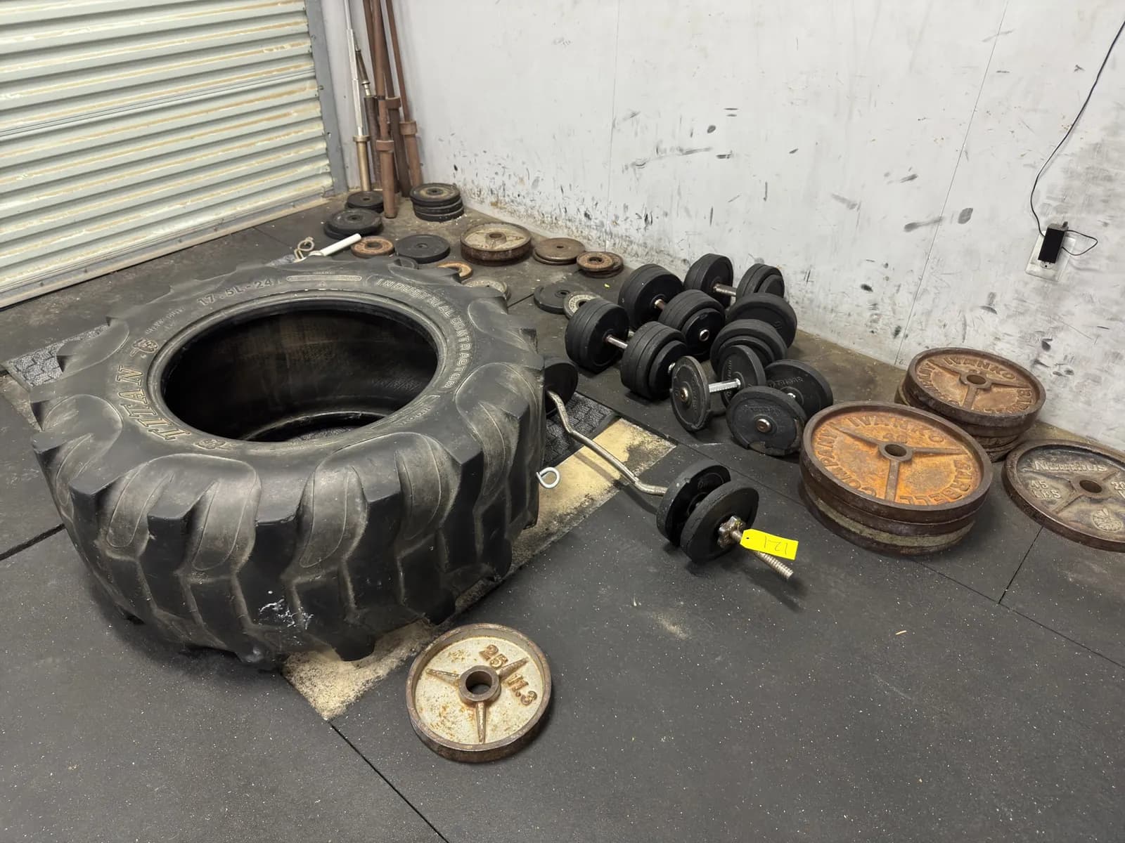 assorted-metal-plate-weights-dumbbells-and-tire-9ac124
